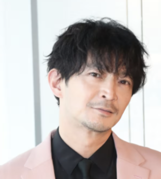 津田健次郎のピンク色のスーツ姿